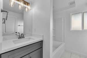 Bathroom with tile patterned floors, vanity, and bathtub / shower combination