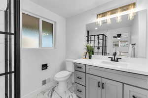 Bathroom featuring ceiling fan, toilet, and vanity