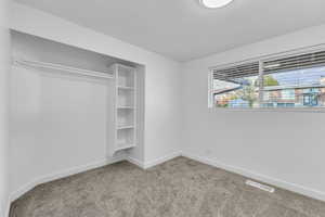 Unfurnished bedroom featuring a closet and light colored carpet