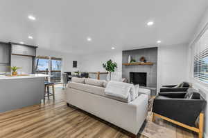 Living room with dark hardwood / wood-style flooring and a brick fireplace