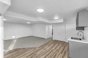 Interior space featuring gray cabinets, sink, and light wood-type flooring