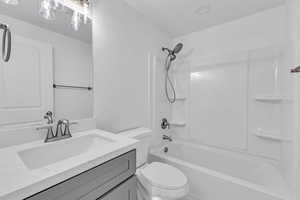 Full bathroom with washtub / shower combination, vanity, and toilet