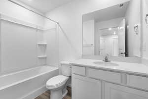 Full bathroom with washtub / shower combination, wood-type flooring, vanity, and toilet