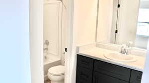 Full bathroom with vanity, toilet, and washtub / shower combination