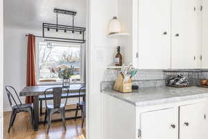 Kitchen featuring light hardwood / wood-style flooring, white cabinets, and a textured ceiling