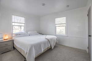 Bedroom featuring light carpet