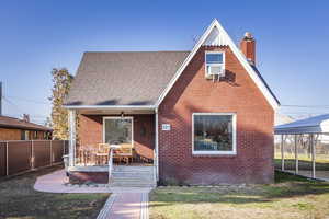 View of front of house with a carport, covered porch, and a front lawn