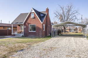 View of front of home with a front yard and a carport