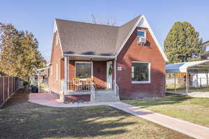 View of front of house featuring a front lawn, a porch, and a carport