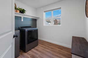 Washroom featuring washer and clothes dryer and dark hardwood / wood-style flooring