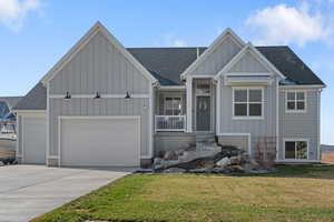 View of front of property featuring a front yard and a garage