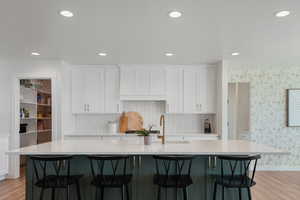 Kitchen with white cabinetry, a spacious island, and light hardwood / wood-style floors