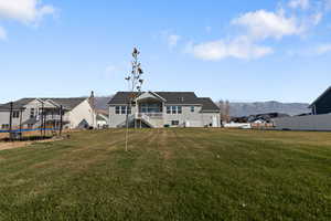 Back of house featuring a lawn and a mountain view