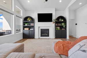 Living room featuring light wood-type flooring, a wealth of natural light, and ceiling fan