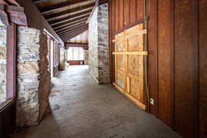 Hallway featuring hardwood / wood-style floors, wood ceiling, and vaulted ceiling