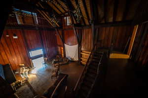 Miscellaneous room featuring high vaulted ceiling and wooden walls