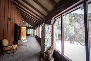 Sunroom / solarium featuring lofted ceiling with beams