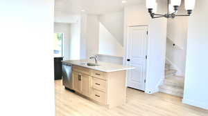 Kitchen with a kitchen island with sink, dishwasher, light hardwood / wood-style floors, and sink