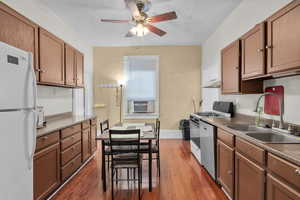 Kitchen with white appliances, exhaust hood, sink, hardwood / wood-style flooring, and ceiling fan