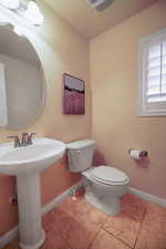 Bathroom featuring tile patterned flooring, toilet, and sink