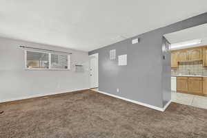 Carpeted spare room with a textured ceiling, a wall mounted AC, and sink