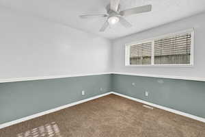 Carpeted spare room with ceiling fan