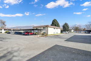 View of vehicle parking featuring a mountain view and a carport