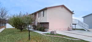 View of side of home with a yard and a patio