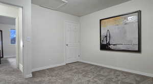 Unfurnished room with carpet and a textured ceiling