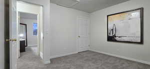 Unfurnished bedroom featuring light colored carpet and a textured ceiling