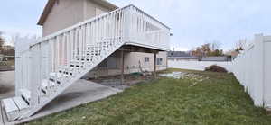 View of side of home with a deck and a yard