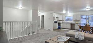 Kitchen featuring a textured ceiling, range with electric stovetop, white cabinetry, and sink