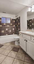 Full bathroom with bathtub / shower combination, a textured ceiling, toilet, vanity, and tile walls