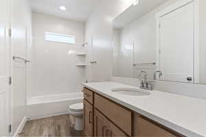 Full bathroom featuring shower / tub combination, vanity, hardwood / wood-style flooring, and toilet