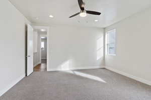 Empty room with ceiling fan and carpet