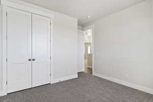 Unfurnished bedroom featuring a closet and carpet floors