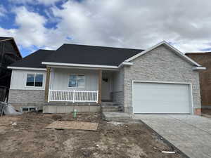 View of front of house with a shingled roof, covered porch, an attached garage, board and batten siding, and driveway