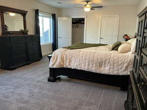 Carpeted bedroom featuring a closet and ceiling fan