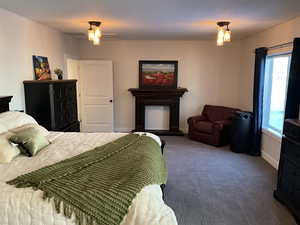 Carpeted bedroom with multiple windows and ceiling fan