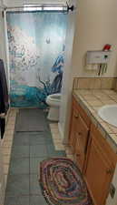 Bathroom with a shower, tile patterned flooring, vanity