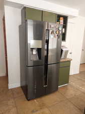 stainless steel fridge and green cabinetry