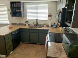 Kitchen featuring kitchen peninsula, sink, light tile patterned floors, and appliances with stainless steel finishes