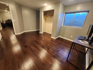 Bedroom 5 with dark hardwood / wood-style floors and a closet