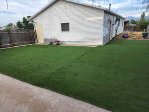 View of backyard featuring artificial turf