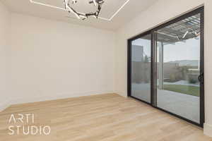 Spare room featuring light hardwood / wood-style floors and a chandelier