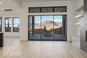 Unfurnished room featuring a mountain view, light hardwood / wood-style floors, and plenty of natural light