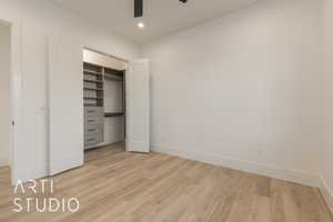 Unfurnished bedroom featuring ceiling fan, a closet, and light wood-type flooring