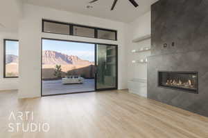 Living room with ceiling fan, light wood-type flooring, and a tile fireplace