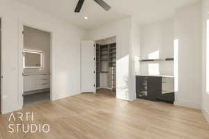 Unfurnished bedroom featuring ensuite bath, ceiling fan, a spacious closet, light hardwood / wood-style flooring, and a closet