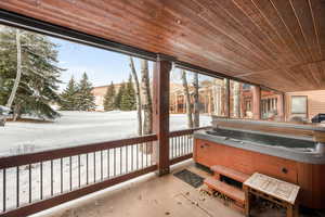 Sunroom / solarium with a hot tub, plenty of natural light, and wood ceiling